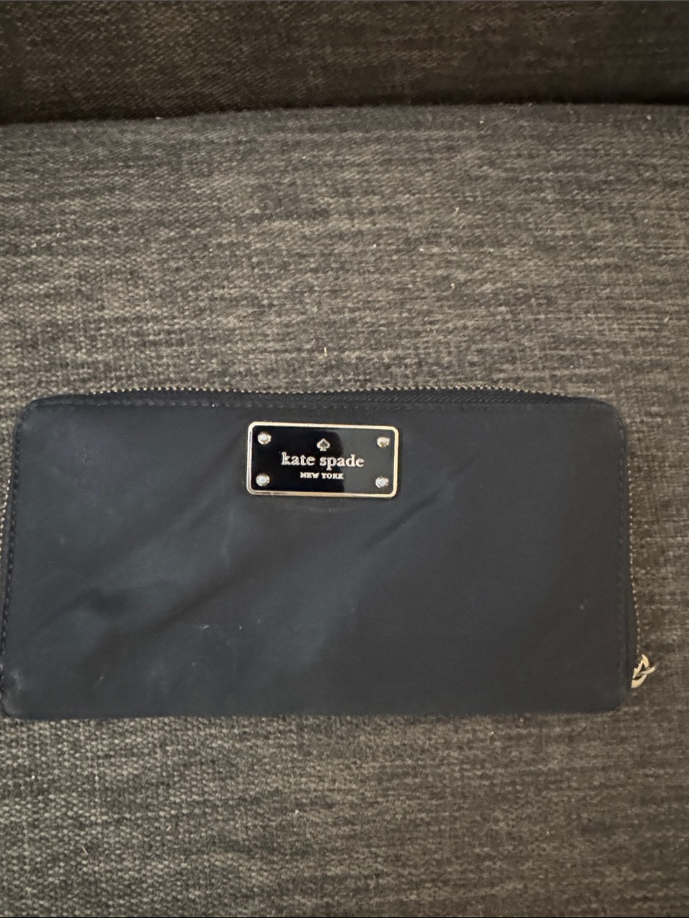 kate spade navy zip-around wallet with gold plaque and credit card slots.